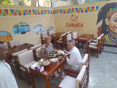 a group of people sitting at a table in a restaurant at Samara Guest House in Aswan