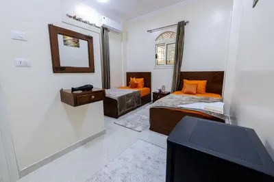 a room with two beds and a tv in it at Samara Guest House in Aswan