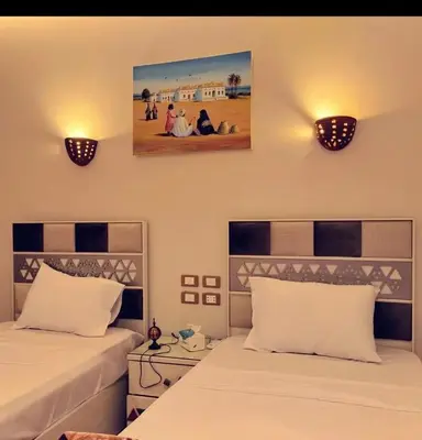 a bedroom with two beds and two lights on the wall at City center NewAswan Aswan 2 in Aswan