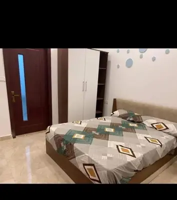 a bedroom with a large bed with a brown door at City center NewAswan Aswan 2 in Aswan