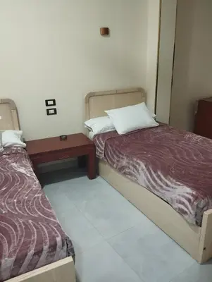a small room with two beds and a table at City center NewAswan Aswan 2 in Aswan