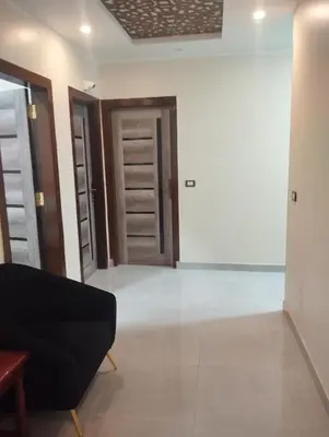 a living room with a black couch and two doors at City center NewAswan Aswan 2 in Aswan