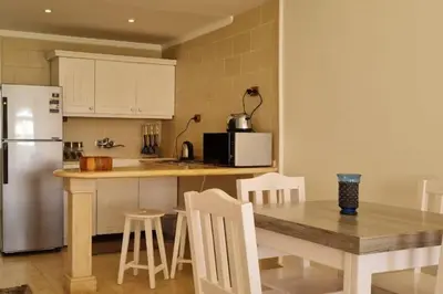 a kitchen with a table and a refrigerator at Nile Front Luxor Apt Sleeps 6 with Pool in Luxor