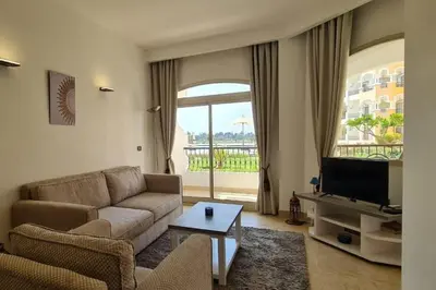 a living room with a couch and a tv at Nile Front Luxor Apt Sleeps 6 with Pool in Luxor