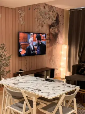 a living room with a table and a tv on a wall at Amazing Mangroovy 1 BD in gouna in Hurghada