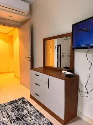 a room with a tv and a dresser with a mirror at Amazing Mangroovy 1 BD in gouna in Hurghada