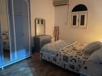 a bedroom with a bed and a dresser and a mirror at MelissaKato in Naj‘ al Maḩaţţah