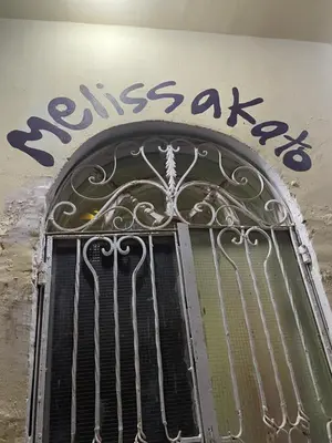 a metal door with a sign on the side of a building at MelissaKato in Naj‘ al Maḩaţţah
