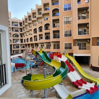 a pool with a water slide in front of a building at Juliana beach in Hurghada