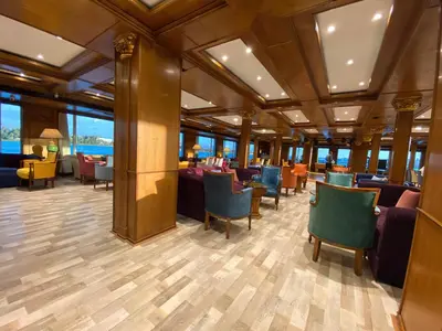 a restaurant with chairs and tables and windows at Nile Cruise 2 nights 3 Days From Aswan to Luxor with tours in Aswan