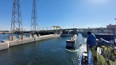a man standing on the side of a boat in a canal at Nile Cruise 2 nights 3 Days From Aswan to Luxor with tours in Aswan