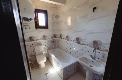 a bathroom with a sink and a tub and a toilet at Wanees Hostel in Aswan