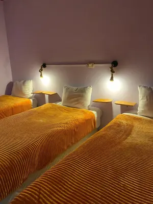 two beds sitting next to each other in a room at Wanees Hostel in Aswan