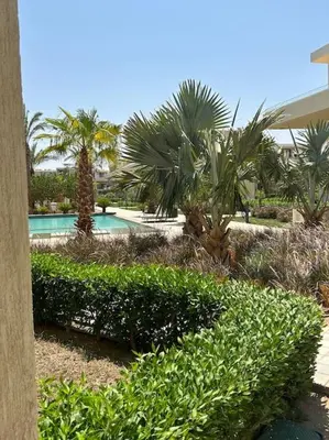 a resort with a pool with palm trees and bushes at Peaceful 1BR studio at G-Crib El Gouna in Hurghada