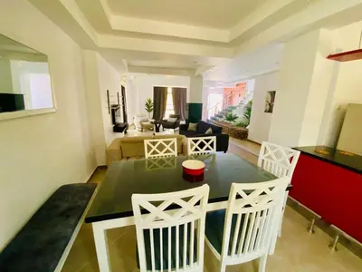 a living room with a table and white chairs at Hurghada-Magawish Villa 5 in Hurghada