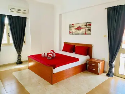 a bedroom with a bed with red pillows on it at Hurghada-Magawish Villa 5 in Hurghada
