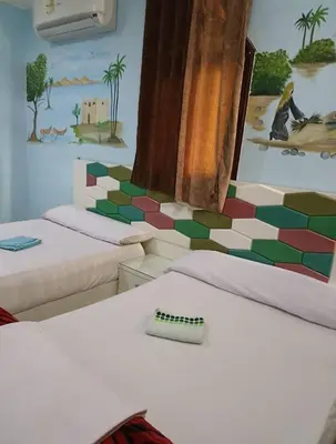 a room with two beds and a painting on the wall at شقق للإيجار بأسوان in Aswan