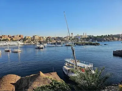 a boat is docked in a river with boats at شقق للإيجار بأسوان in Aswan