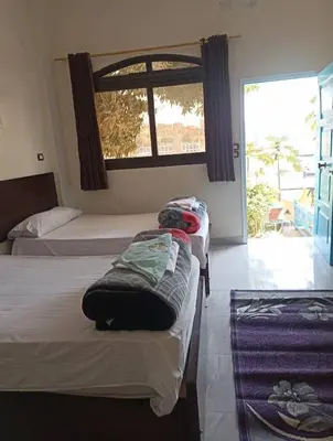 a bedroom with two beds and a window with a view at شقق للإيجار بأسوان in Aswan
