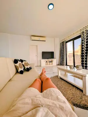 a person laying on a couch in a living room at Das Nistkästchen in Hurghada in Hurghada
