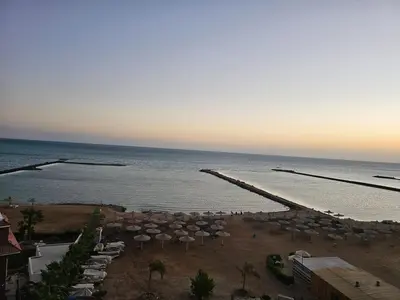 a view of a beach with umbrellas and the ocean at Das Nistkästchen in Hurghada in Hurghada