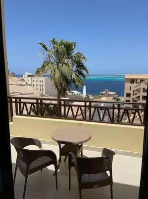 a table and chairs on a balcony with a view of the ocean at The view hurghada in Hurghada