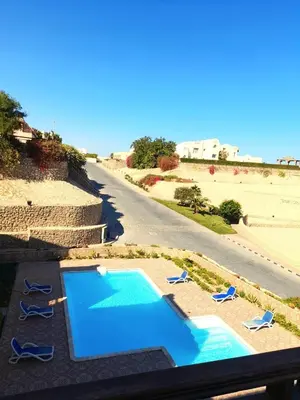 an overhead view of a swimming pool with chairs and a road at The view hurghada in Hurghada