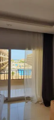 a bedroom with a window with a view of a balcony at Studio in Selena Bay Hurghada in Hurghada