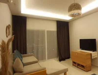 a living room with a couch and a flat screen tv at Studio in Selena Bay Hurghada in Hurghada