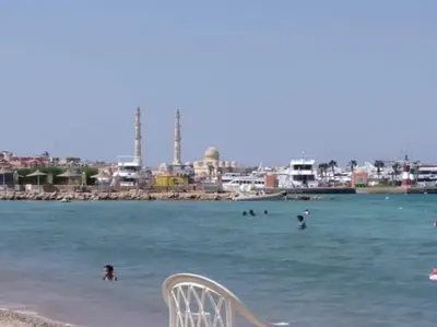 a chair sitting in the water at a beach at Sheraton Plaza house near the beaches and near New Marina studio 428 in Hurghada