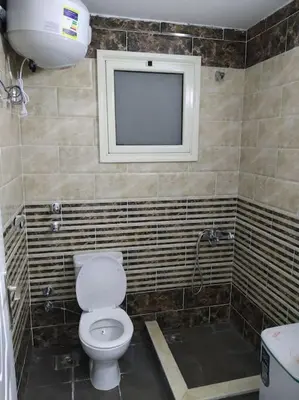 a bathroom with a toilet and a television on the wall at Sheraton Plaza house near the beaches and near New Marina studio 428 in Hurghada