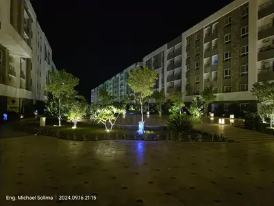 a building with trees and lights in a courtyard at night at Fanadir sea view Appartment in Hurghada