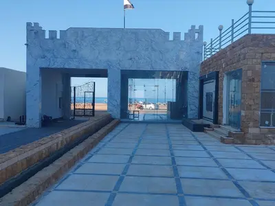 a building with doors and a view of the beach at Studio FOR RENT IN ELWAZRA EREA BEFOR EL GOUNA 5 MINUTES ONE BEDROOM in Hurghada