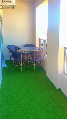 a room with a table and chairs on a green floor at جوليانا بتش in Hurghada