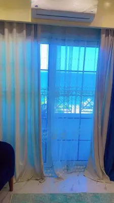 a room with blue curtains and a large window at جوليانا بتش in Hurghada