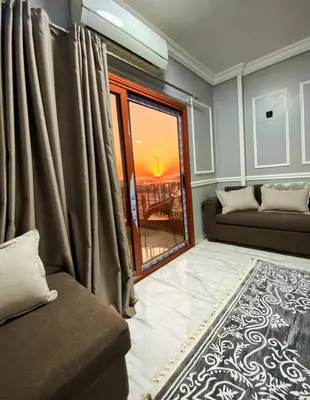 a living room with a couch and a window at Luxor family apartment in Luxor