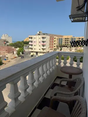a balcony with two chairs and a table on a balcony at Apartment all yours in Hurghada