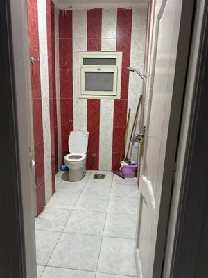 a bathroom with a toilet and red and white stripes at Apartment all yours in Hurghada