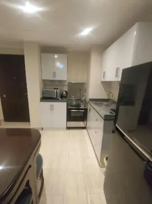 a kitchen with white cabinets and black appliances at Diamond Lily Aldau heights Hurghada rent one bedroom apartment in Hurghada