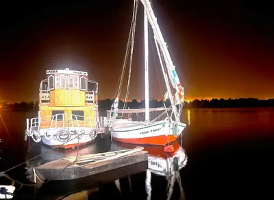 two boats are docked at a dock in the water at Magic Quest Retreat 10 min von Aswan in Nag` el-Fuqâhi