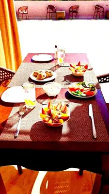 a wooden table with plates of food on it at Magic Quest Retreat 10 min von Aswan in Nag` el-Fuqâhi