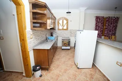 a kitchen with a refrigerator and a counter top at Morning Star Apartment in Luxor