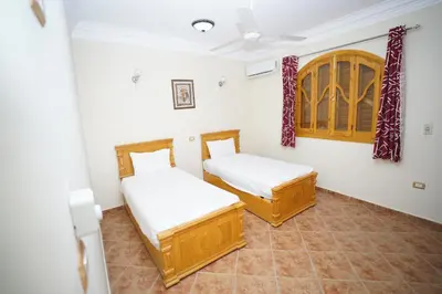 two beds in a room with white walls at Morning Star Apartment in Luxor