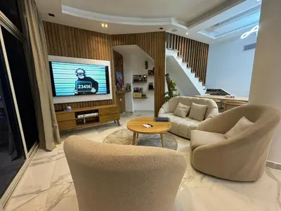 a living room with two chairs and a television at Luxury Smart Home- Villa Duplex in Hurghada
