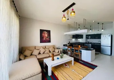 a living room and kitchen with a couch and a table at Cozy 3 Bedrooms Apartment at Cyan El-Gouna in Hurghada