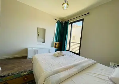 a bedroom with a large bed and a large window at Cozy 3 Bedrooms Apartment at Cyan El-Gouna in Hurghada