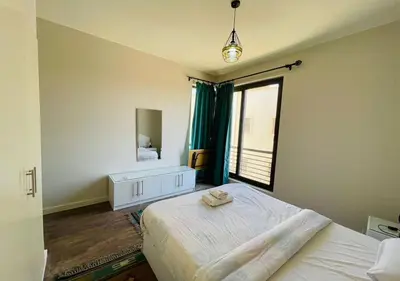 a bedroom with a bed and a mirror and a window at Cozy 3 Bedrooms Apartment at Cyan El-Gouna in Hurghada