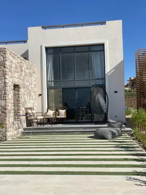 a house with a large window and a patio at Cozy 2BR Seaview loft in Mesca Somabay in Hurghada