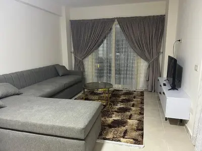 a living room with a couch and a television at Tiba gollden resort in Hurghada