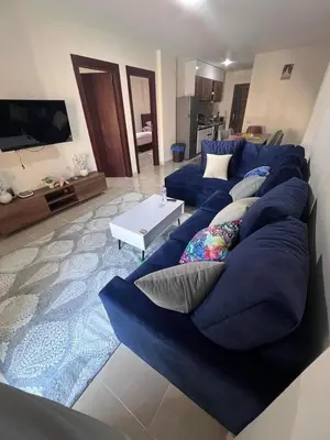 a living room with a blue couch and a table at Tiba gollden resort in Hurghada